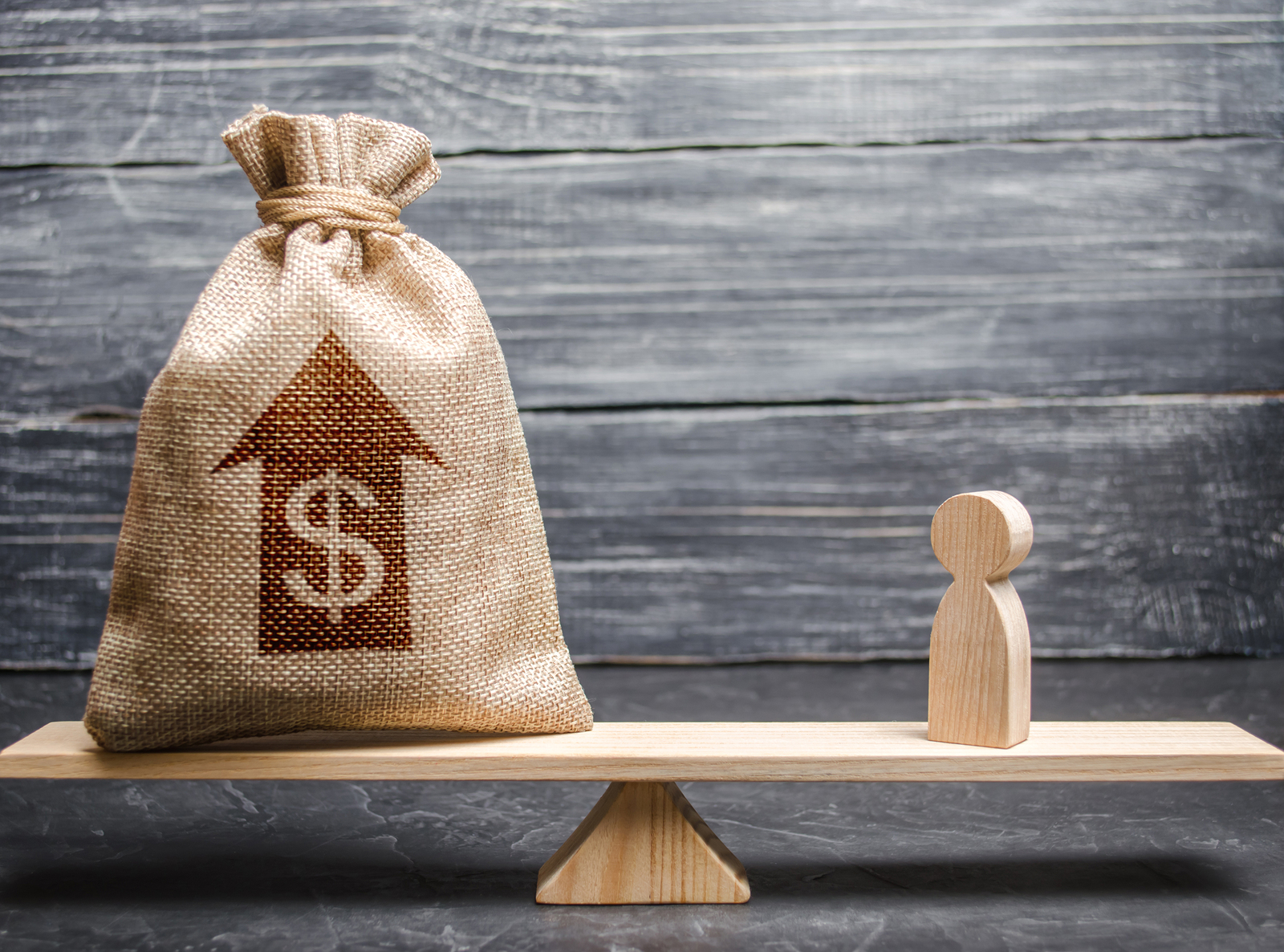 Money Bag With Up Arrow And Man Figurine On Scales.