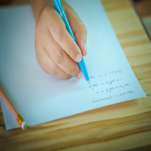 Student testing in exercise exams with blue pen on advanced mathematics (maths) in vintage style.