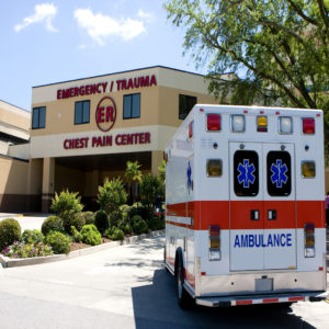 An ambulance pulls into a modern hospital emergency room entrance.