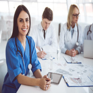 Doctors sitting at table looking happy because they receive above average wage