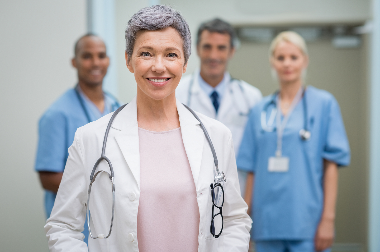 Locum female doctor in front of her medical staff.