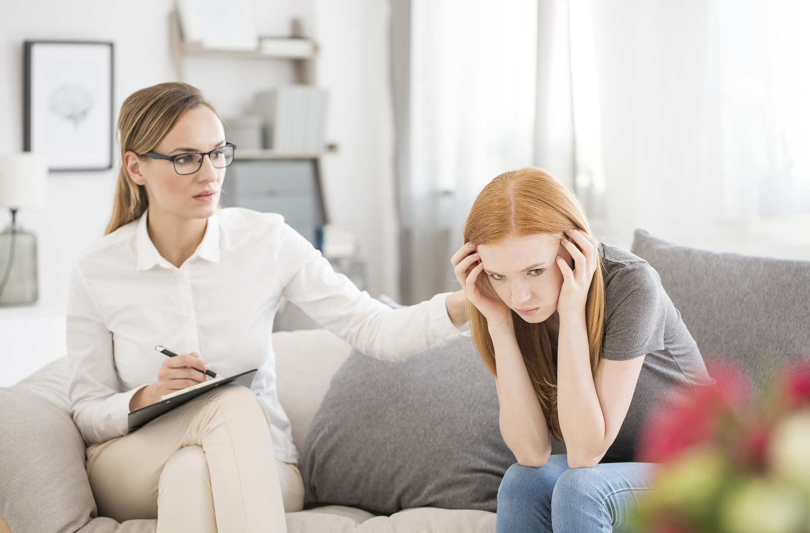 Young unhappy girl suffering form mental breakdown during session with psychiatrist