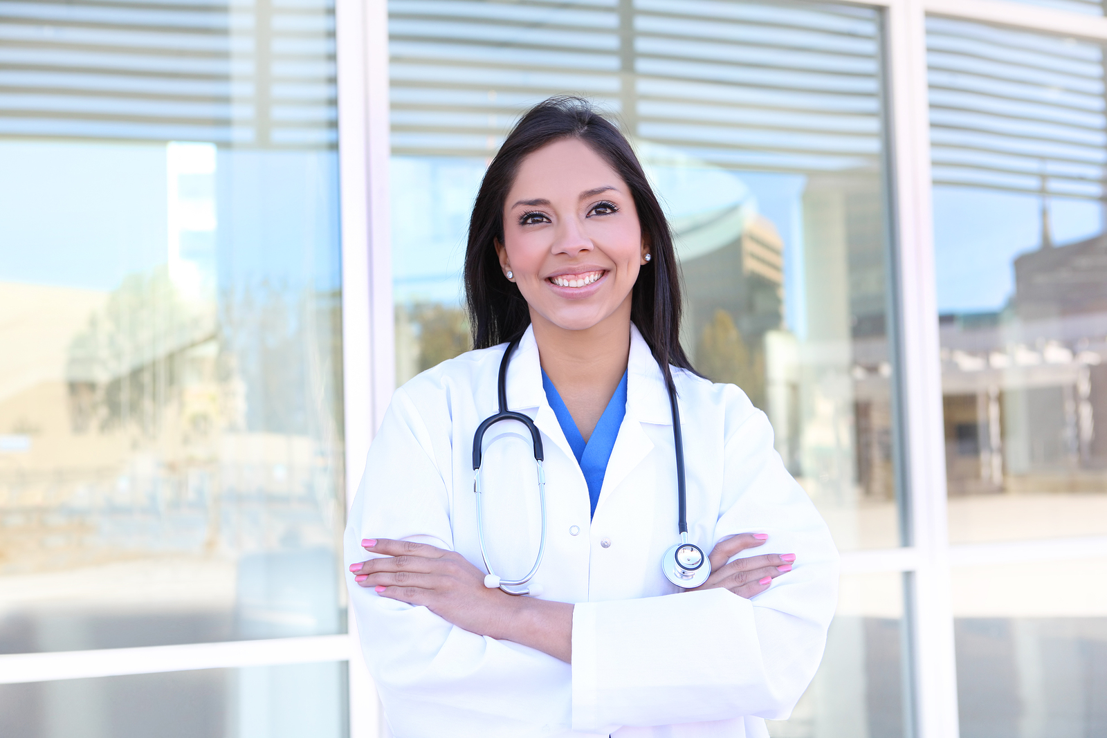 A pretty young woman locum nurse outside hospital building