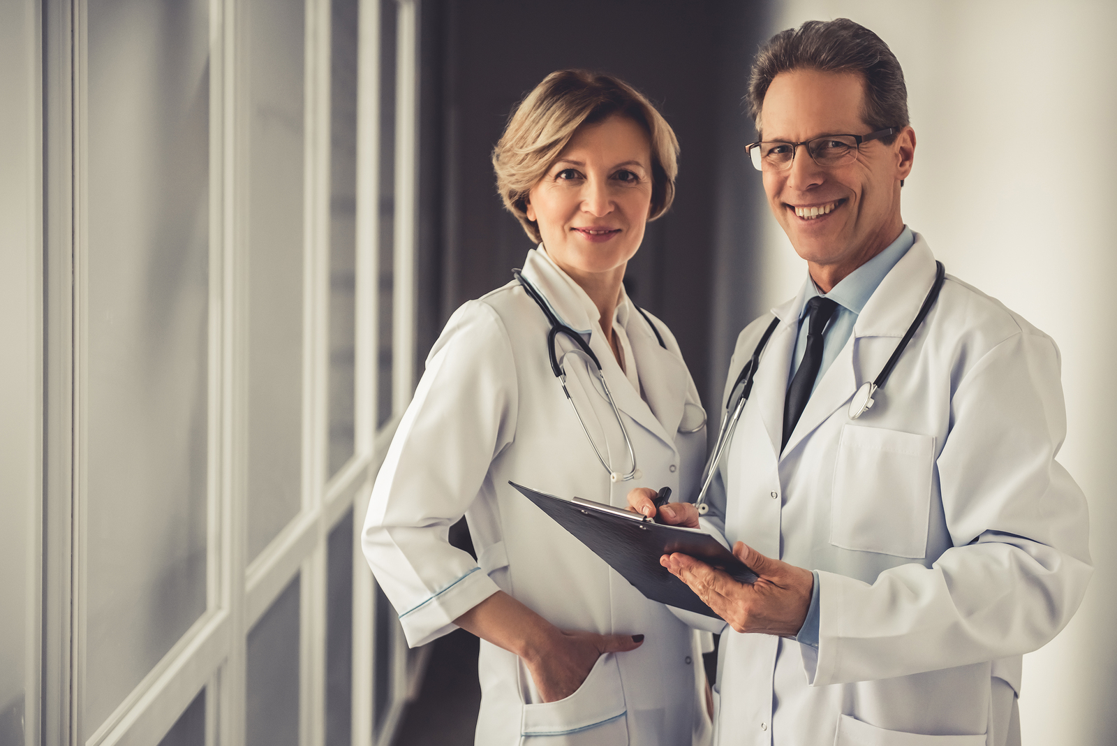 Beautiful mature doctors in hospital corridor