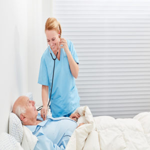 Nurse or doctor with stethoscope examines patient in hospital